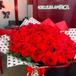 Buquê Quero Você com 50 rosas vermelhas colombianas importadas em embalagem com corações e laço de cetim